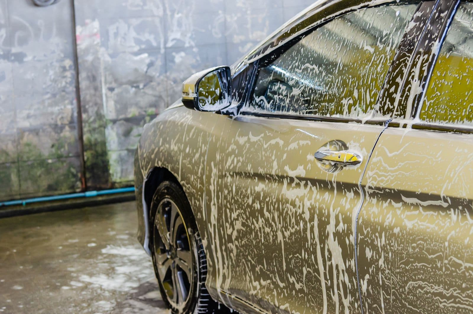 Voiture couverte de mousse dans une station de lavage traditionnelle
